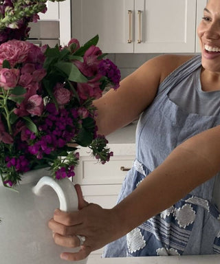 Woman looking at a vase of flowers