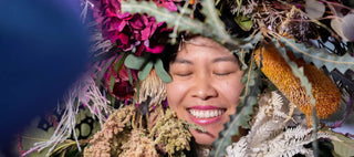 AAPI Woman smiling while wearing a flower crown